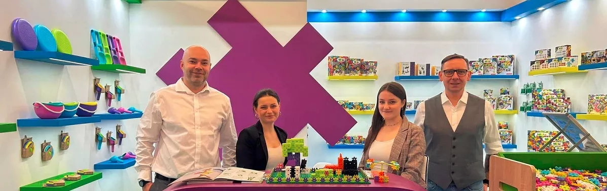 Equipo de Bloques Meli en su stand de feria rodeado de sets de construcción y juguetes educativos
